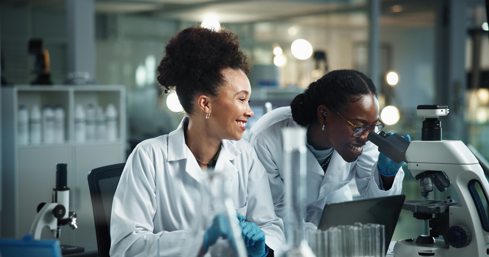 Foto de duas mulheres negras trabalhando em um laboratório.