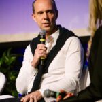 Foto de Fernando Modé falando ao microfone durante sua participação no painel dos CEOs.