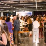 Foto de um grupo de pessoas comendo e conversando durante o happy four de comemoração dos 10 anos do Movimento Mulher 360.