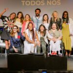 Foto de um grupo diverso de pessoas sobre o palco do Teatro Vivo no encerramento do evento de comemoração dos 10 anos do Movimento Mulher 360.