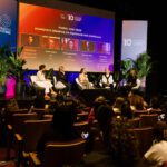 Foto do painel com CEOs e a mediação da Margareth, com parte da plateia aparecendo.