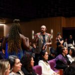 Foto de Leticia Vidica e JP Polo interagindo entre si no meio da plateia.